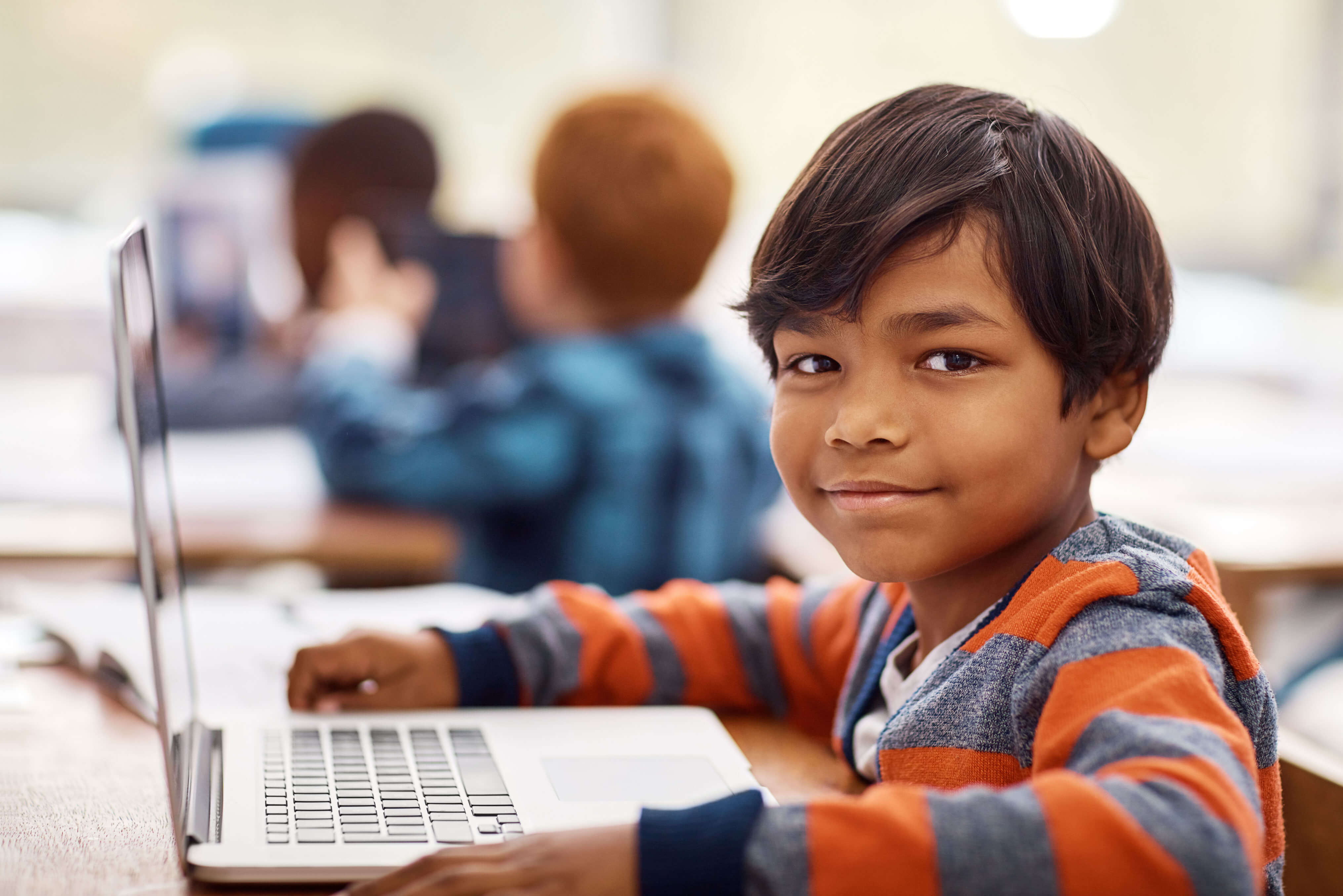 Portrait of an elementary school boy using a laptop while working in class